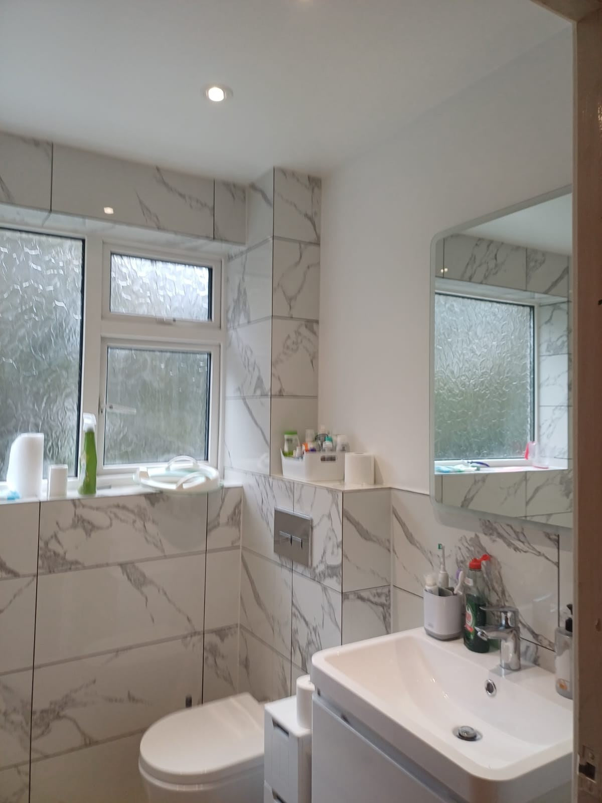 Toilet with a concealed cistern beside the vanity basin