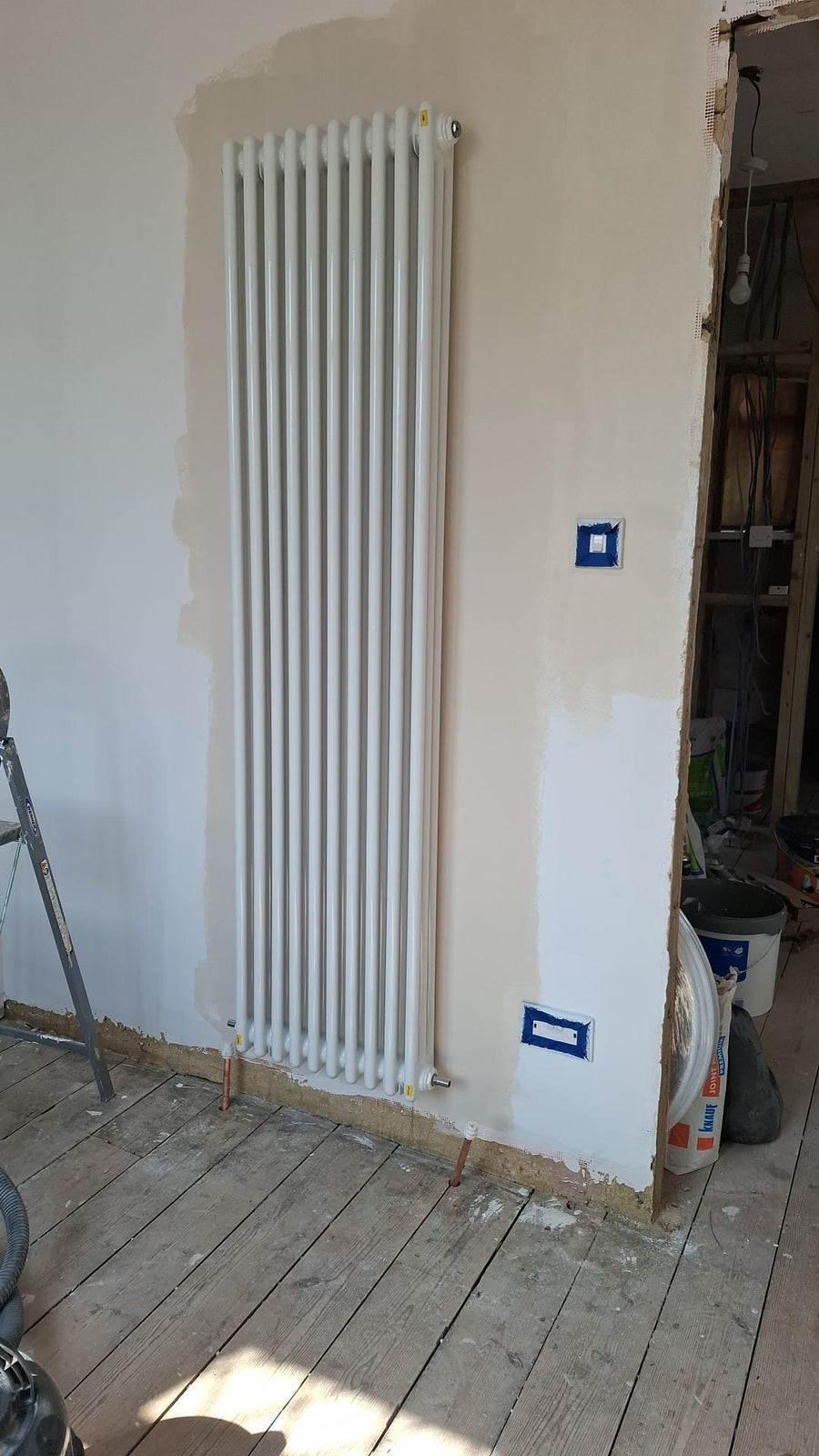 Fresh paint going on around a new column radiator