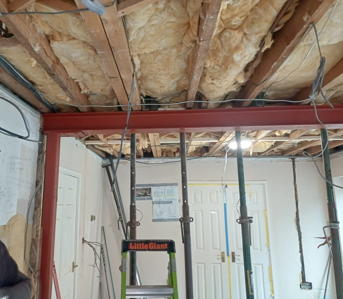 A new steel beam in place, with props supporting the ceiling