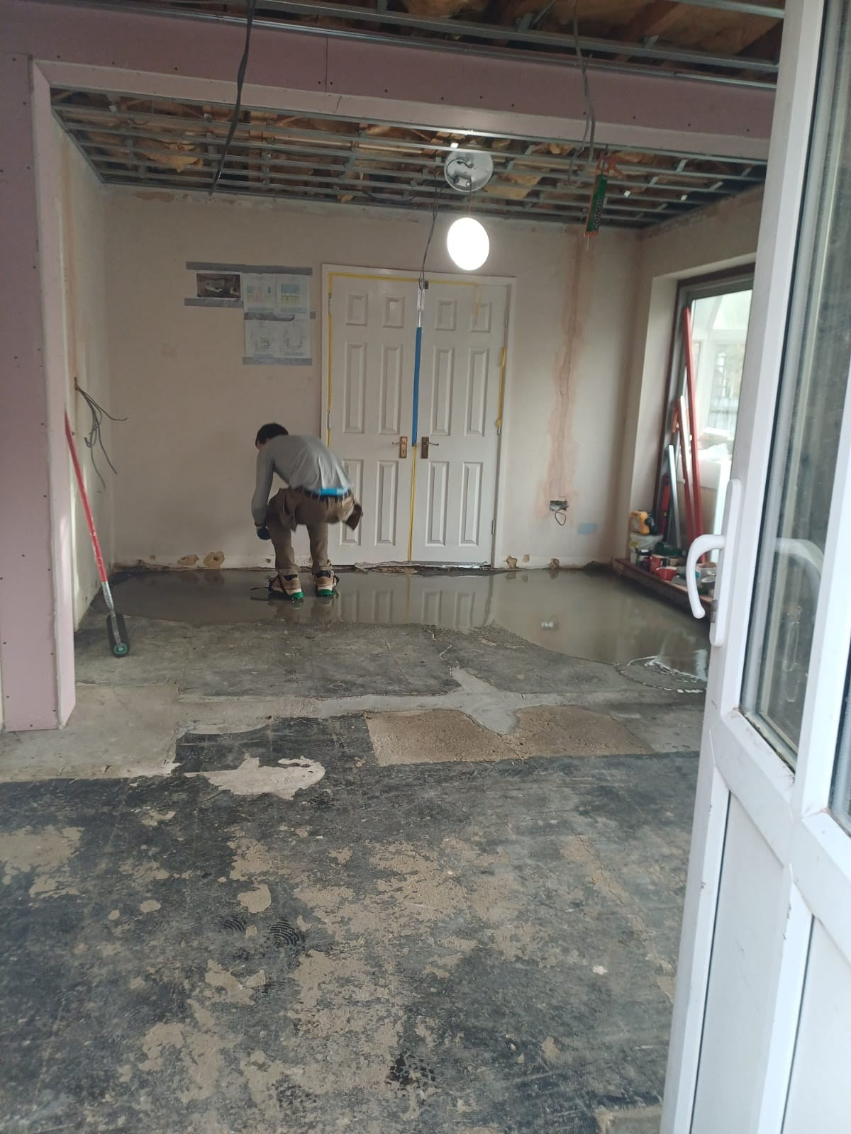 The floor being prepared, with metal framing across the ceiling
