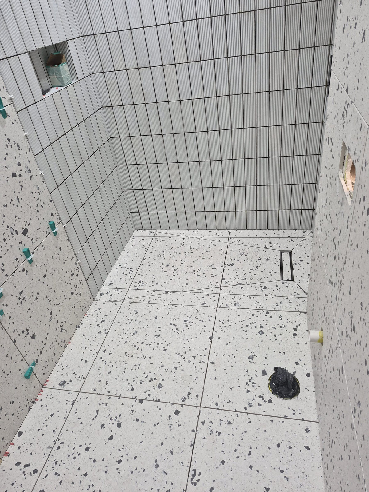 Walk-in shower floor finished with a linear drain