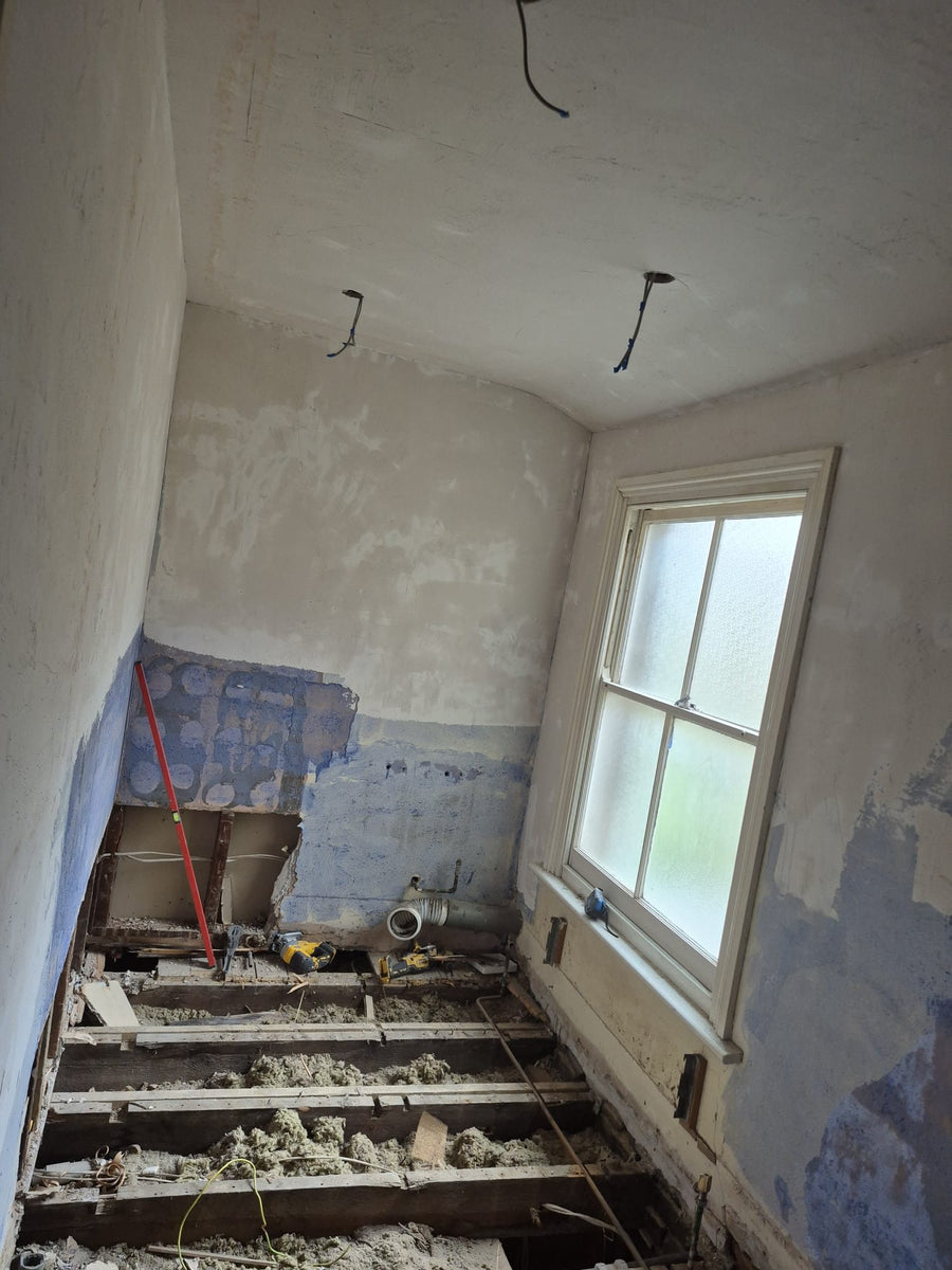 The old bathroom stripped back to the floor joists