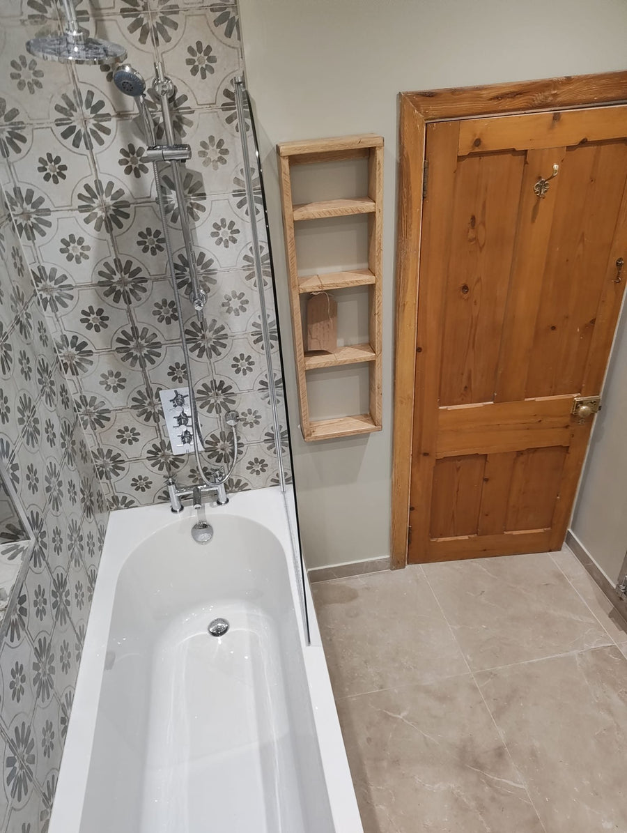 Shower bath with a glass screen beside open timber shelving