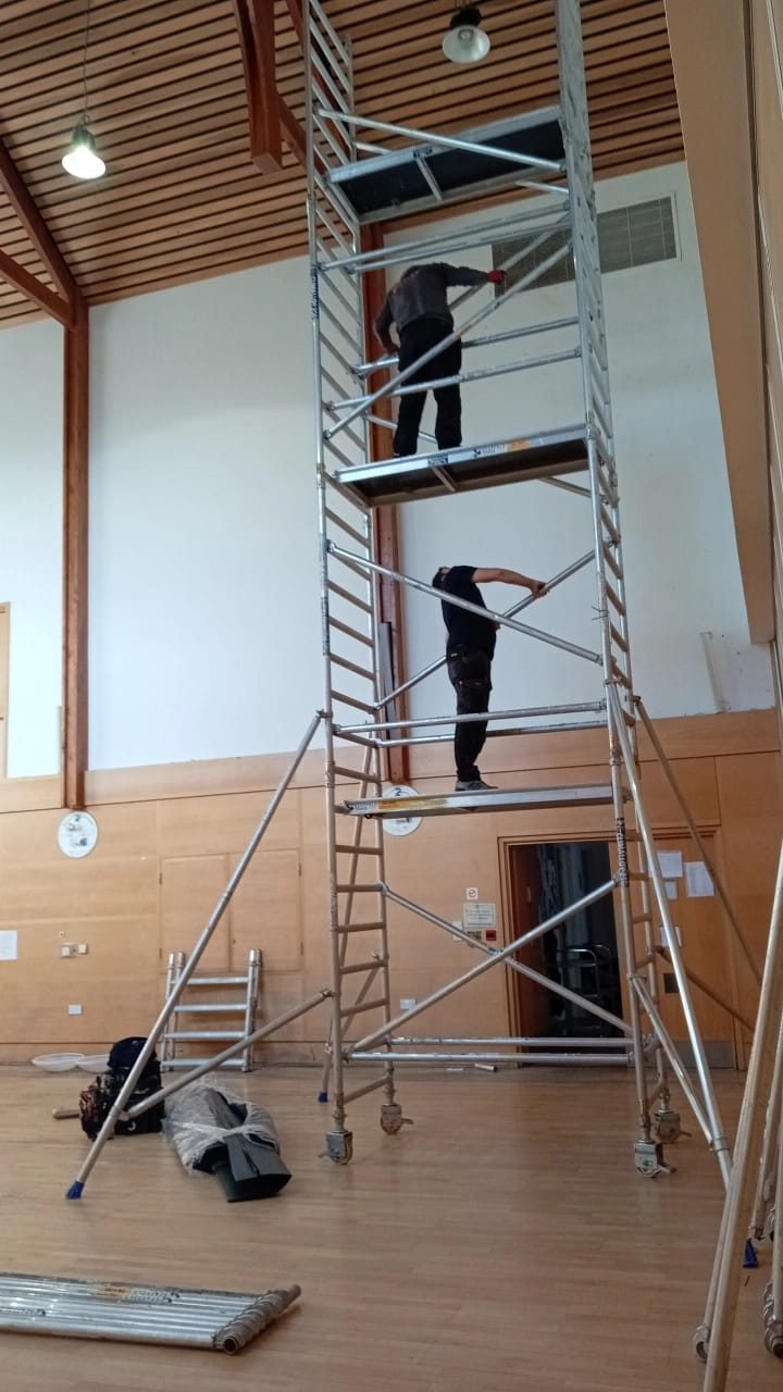 Working from a scaffold tower in the church hall