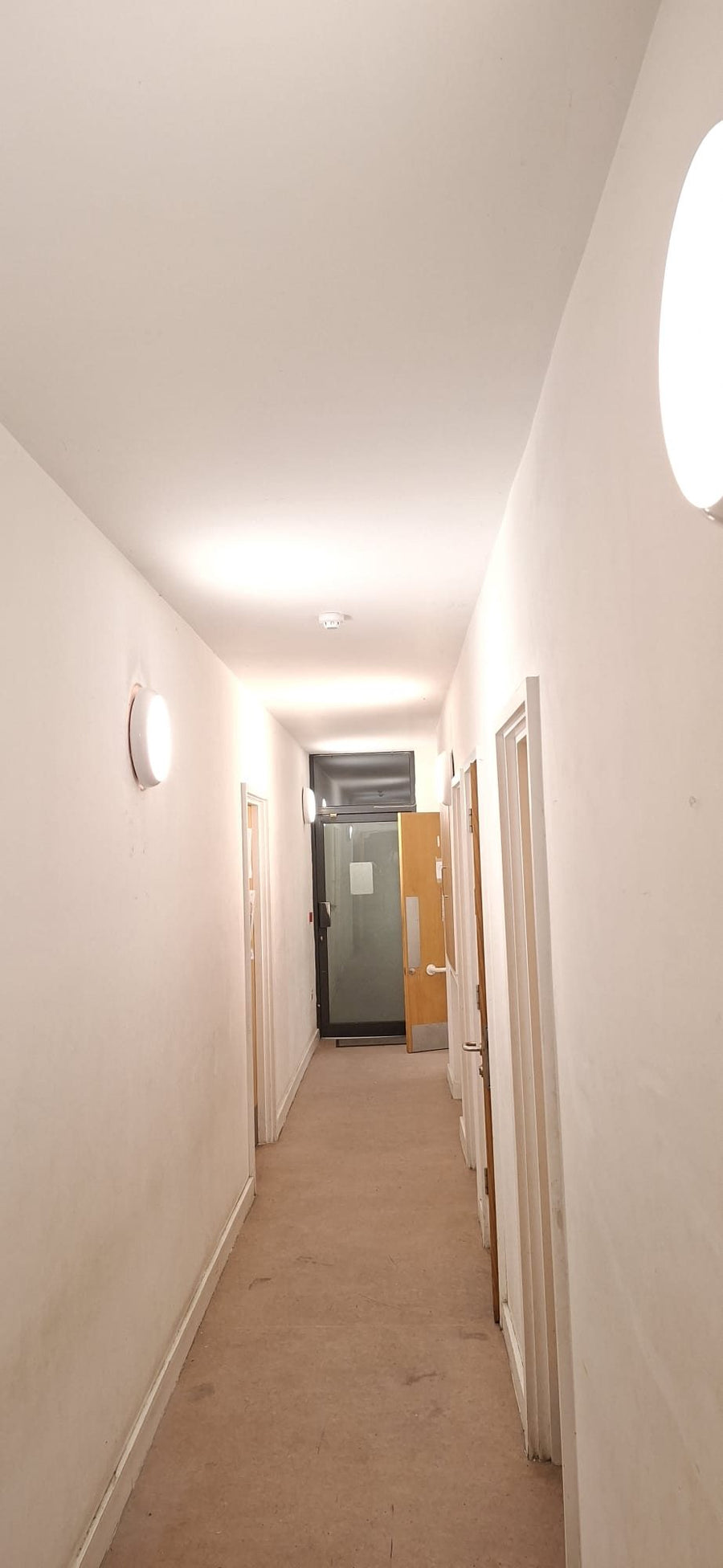 Round LED bulkhead lights along a corridor