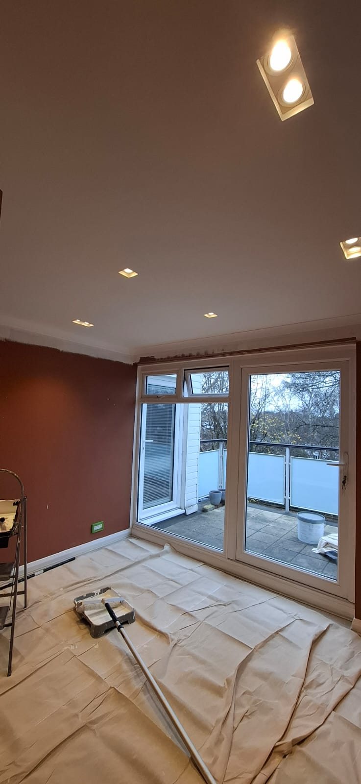 A warm feature wall painted with the floor protected