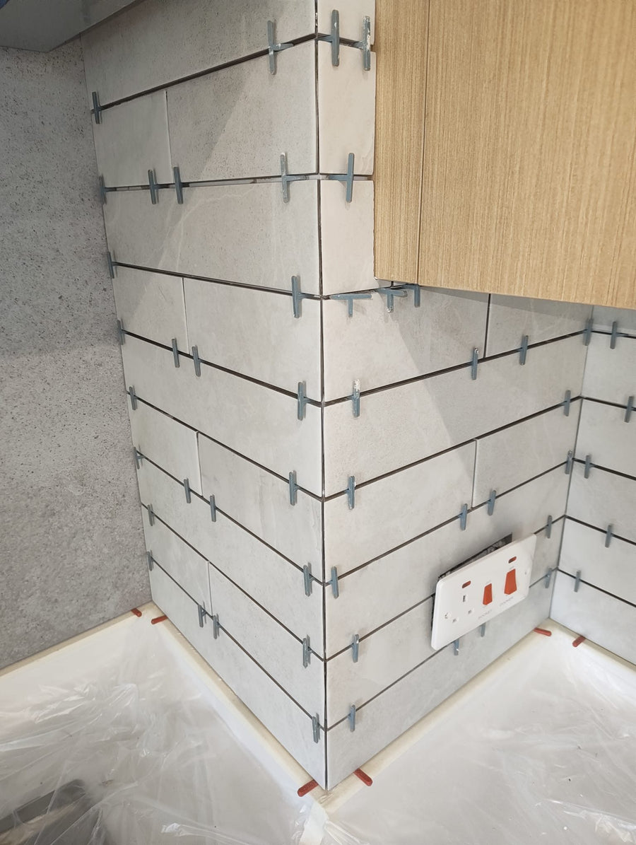 Large-format wall tiles set with levelling clips