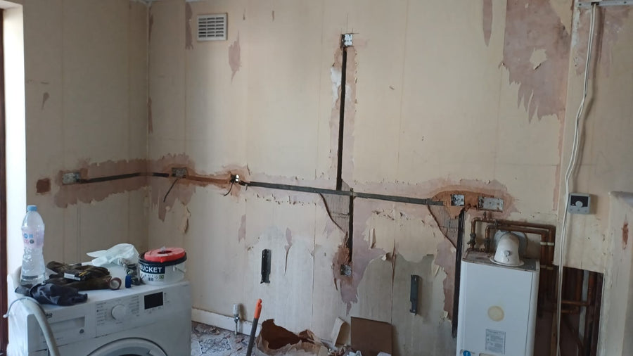 Cable chases filled beside the washing machine and boiler
