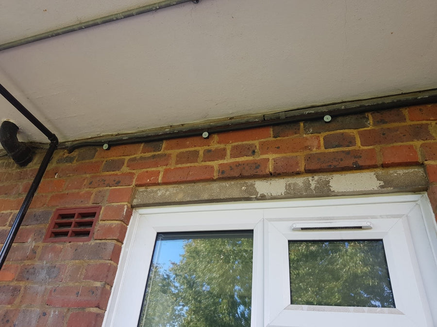 The armoured cable clipped along the outside wall