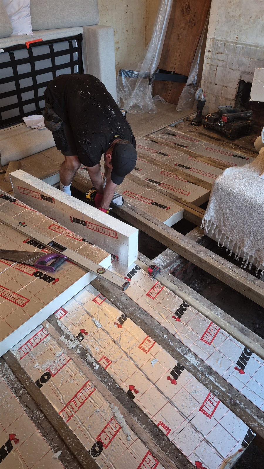 Insulation boards cut to fit between the joists