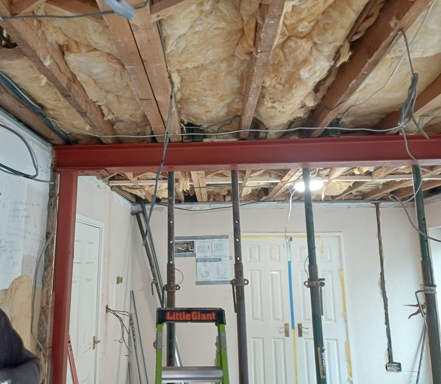 A new steel beam in place, with props supporting the ceiling