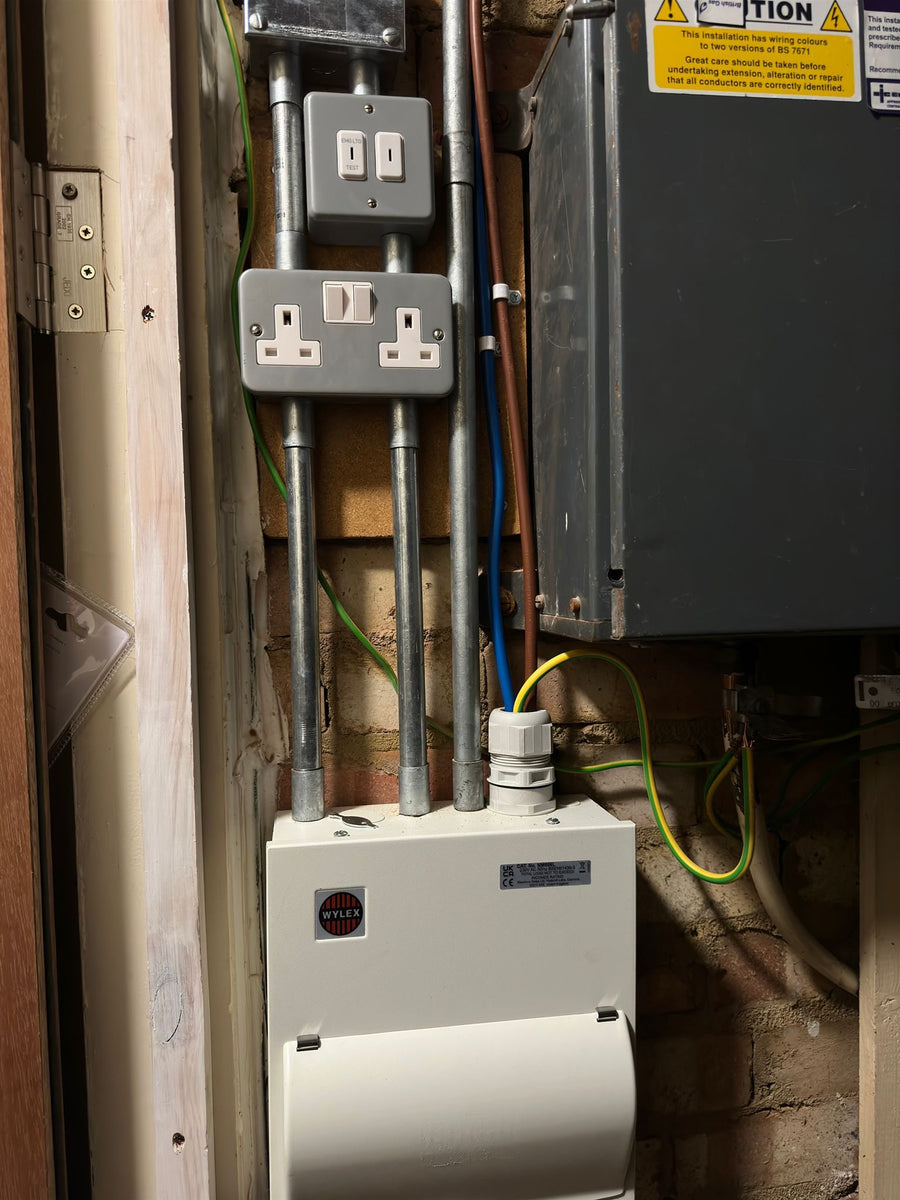 Galvanised conduit feeding a new board and sockets