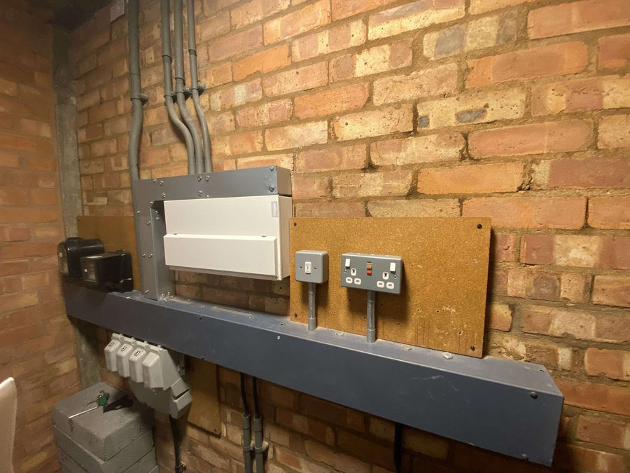 A new board, trunking and sockets on a brick wall