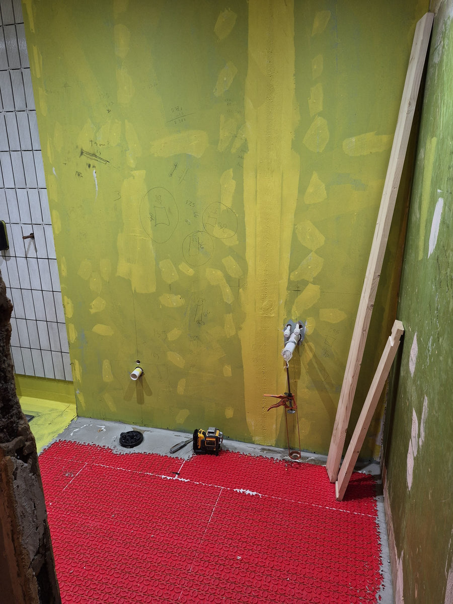 Pipework positioned on the waterproofed wall before tiling