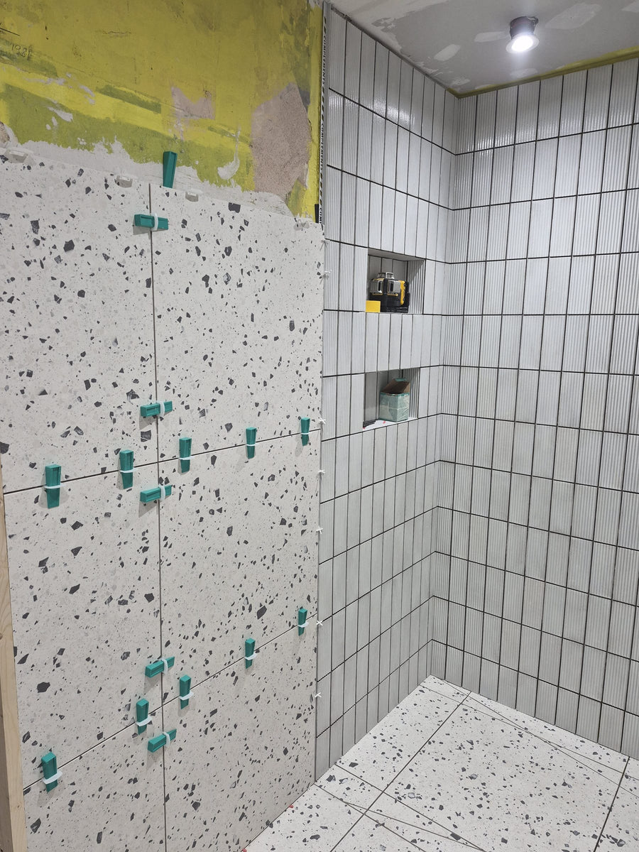 Wall tiles set with levelling clips beside the tiled niches