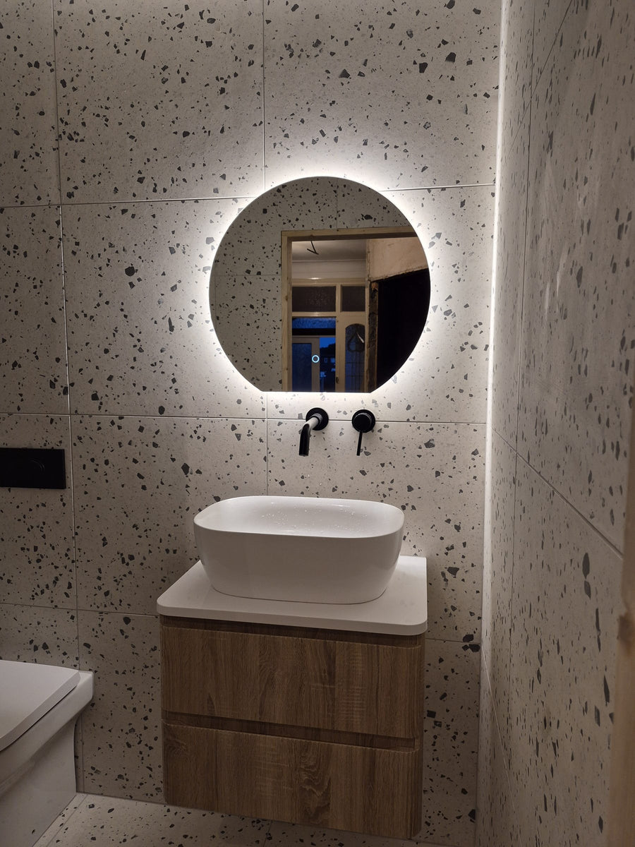 Wall-mounted matt black taps, backlit mirror and LED strip lighting