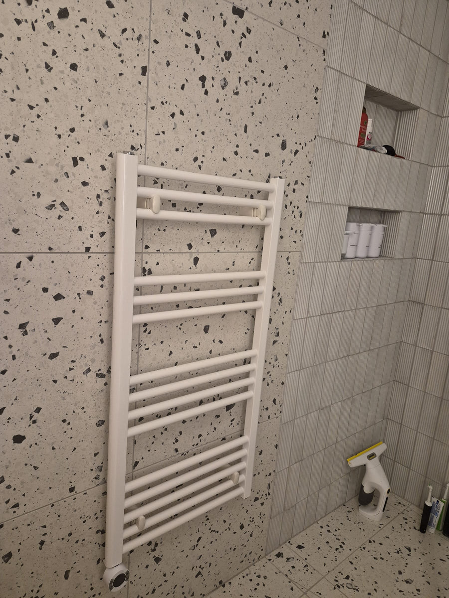 Heated towel rail beside the tiled shower niches