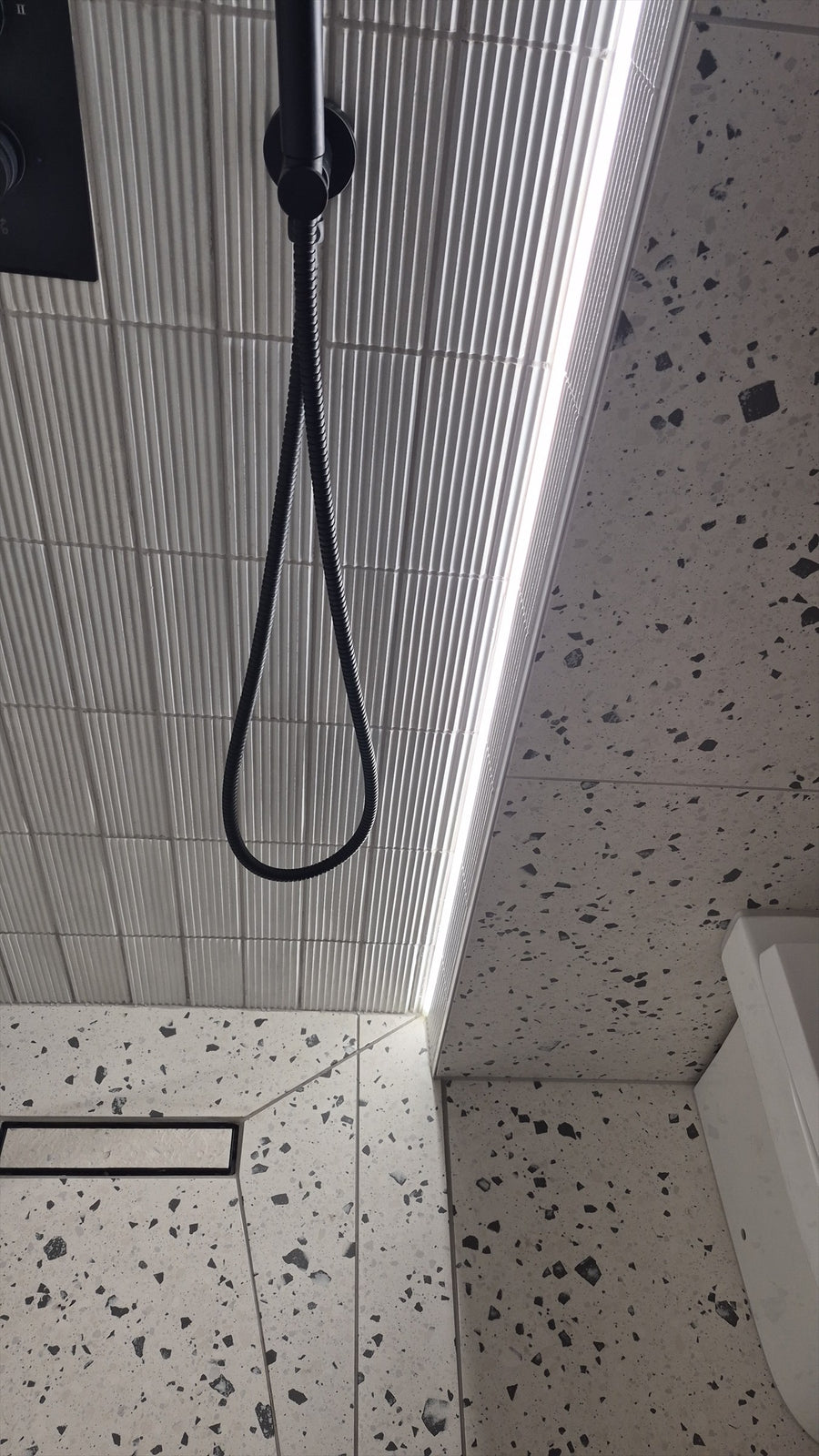 LED strip lighting running down the corner of the walk-in shower