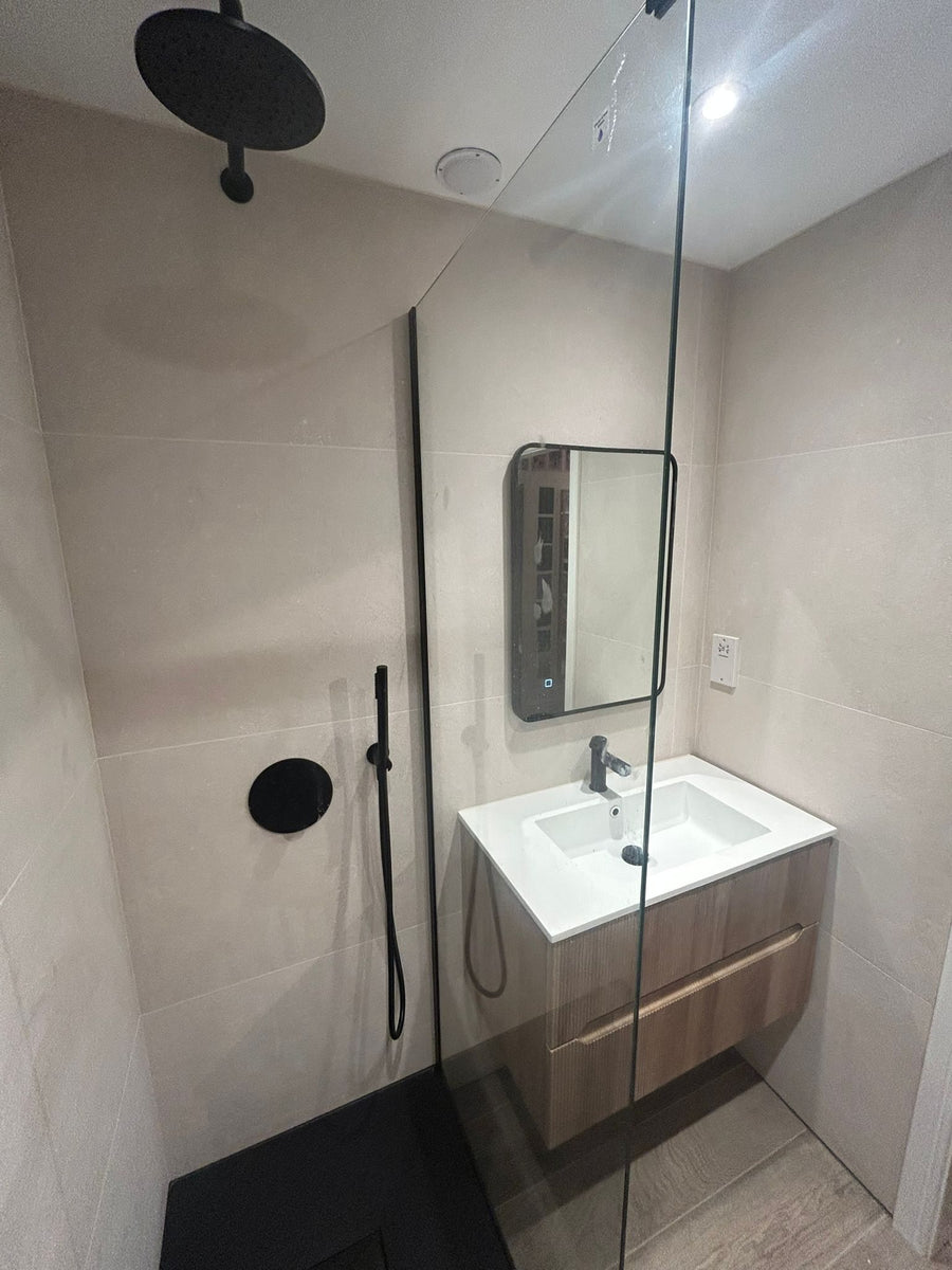 Walk-in shower with a matt black rainfall head and handset