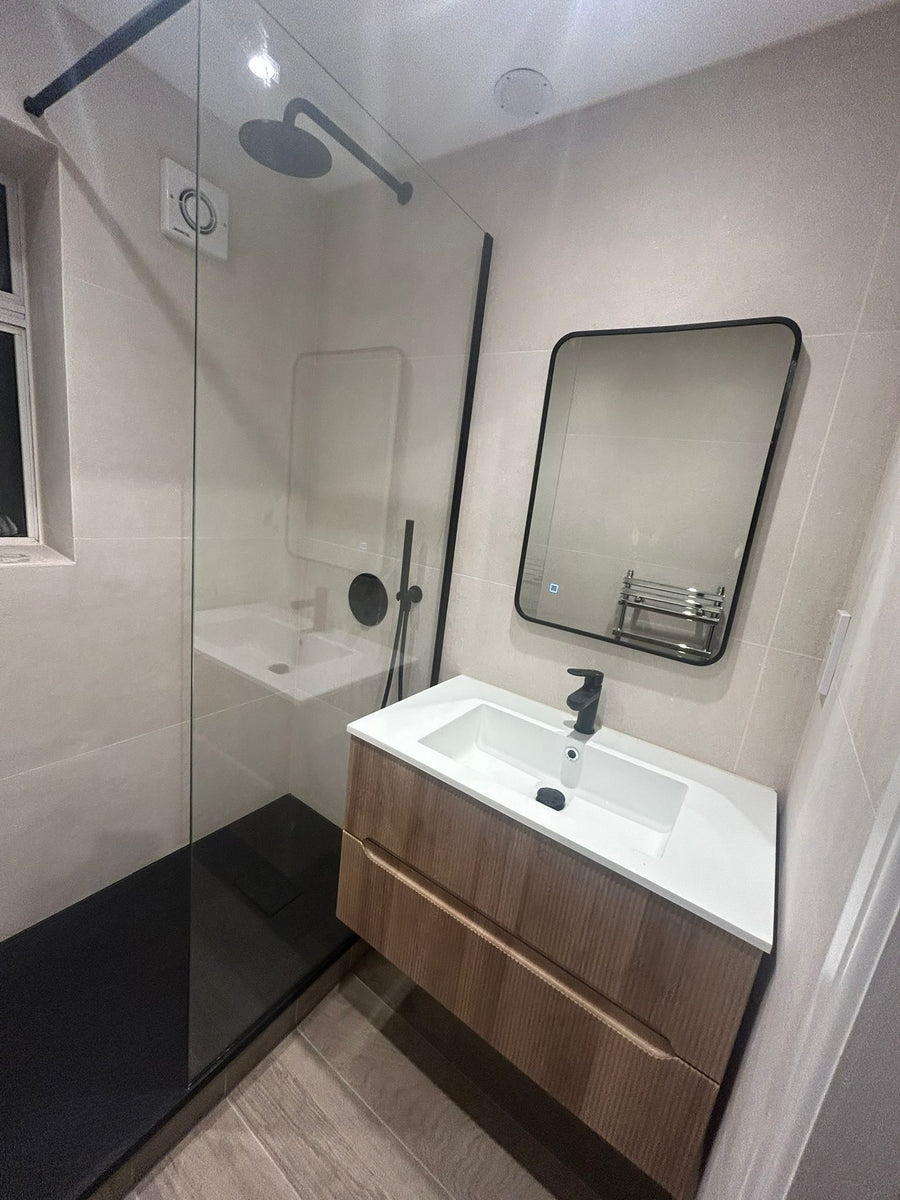 Wall-hung vanity unit and black-framed mirror