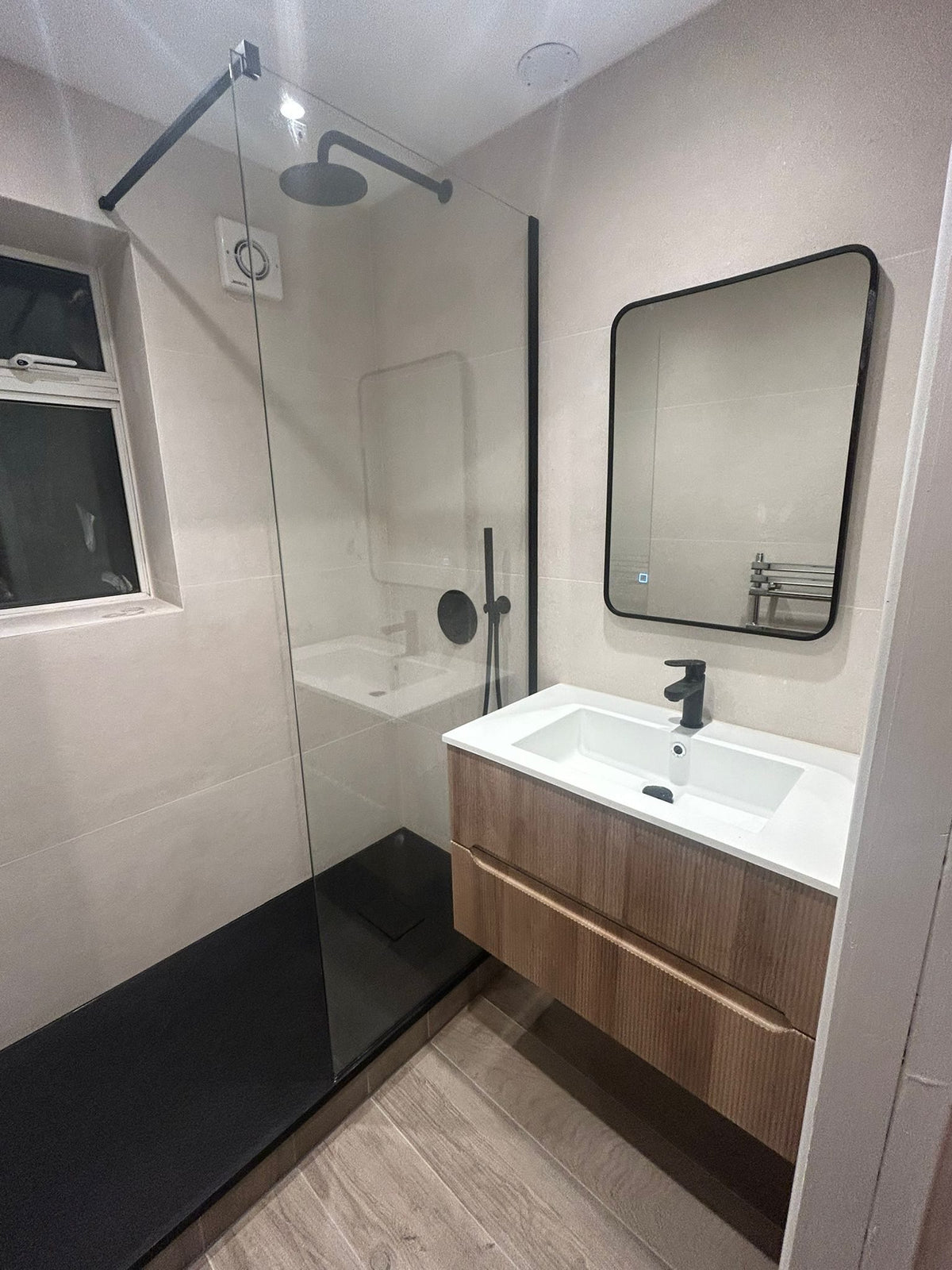 Slate-effect shower tray behind the glass screen